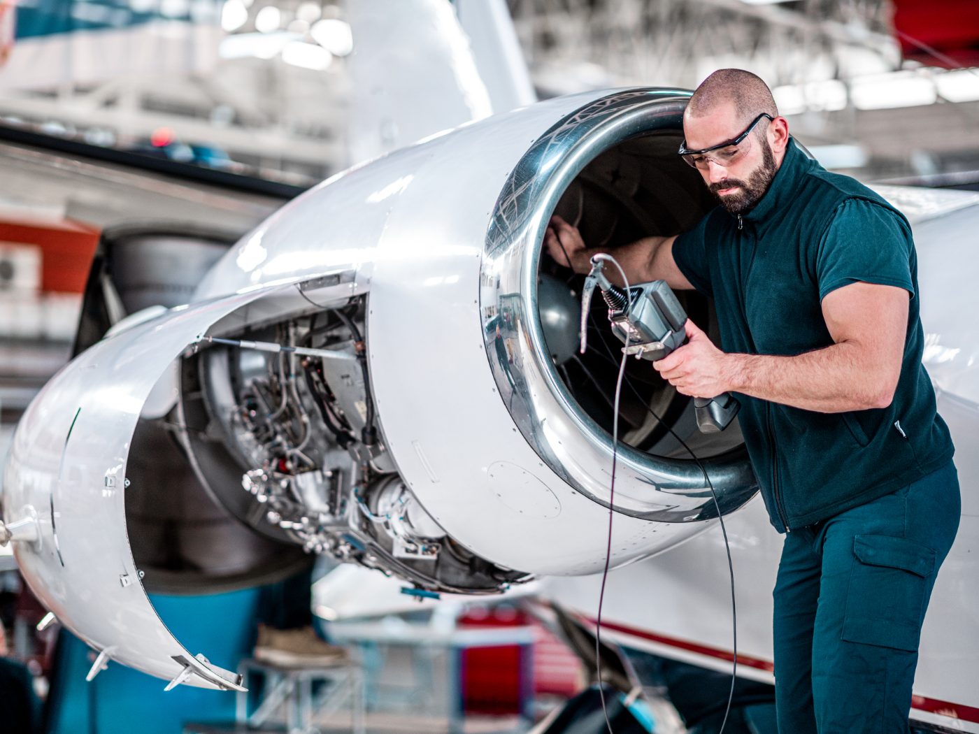Technician inspecting a business jet engine with a borescope
