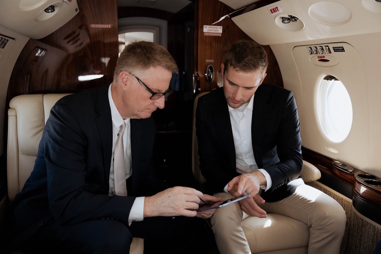 Two advisors reviewing aircraft documents in a cabin