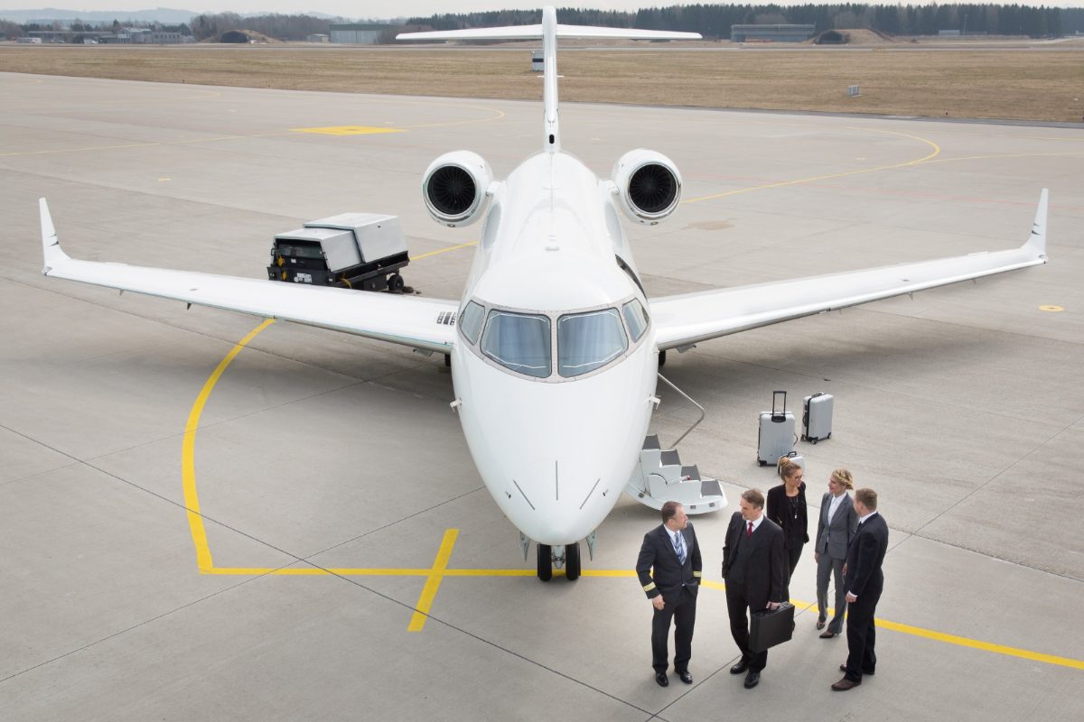 Executives meeting their crew beside a business jet on the ramp